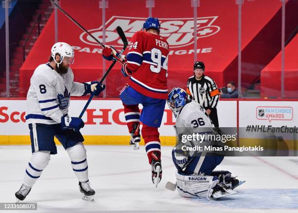 Corey Perry of the Montreal Canadiens jumps in between Jake Muzzin of the Toronto Maple Leafs and goaltender Jack Campbell during the second period...