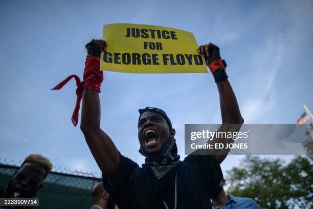 Black Lives Matter protesters holds a placard and shouts slogans during a march on the anniversary of the death of George Floyd, in Brooklyn, New...