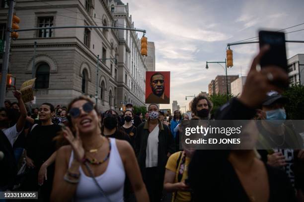 Black Lives Matter protesters hold placards and shout slogans during a march on the anniversary of the death of George Floyd, in Brooklyn, New York...