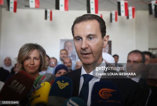 Syrian President Bashar al-Assad talks to the media after casting his vote with his wife, Asma , at a polling station in Douma, near Damascus on May...