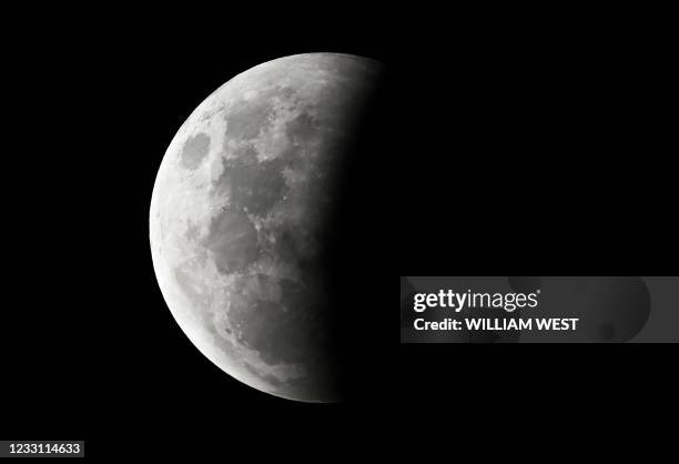 The full moon is seen during the partial eclipse in Melbourne on May 26, 2021 as stargazers across the Pacific are casting their eyes skyward to...