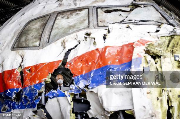 Presiding judge Hendrik Steenhuis views the reconstructed wreckage of Malaysia Airlines Flight MH17, at the Gilze-Rijen military airbase, southern...