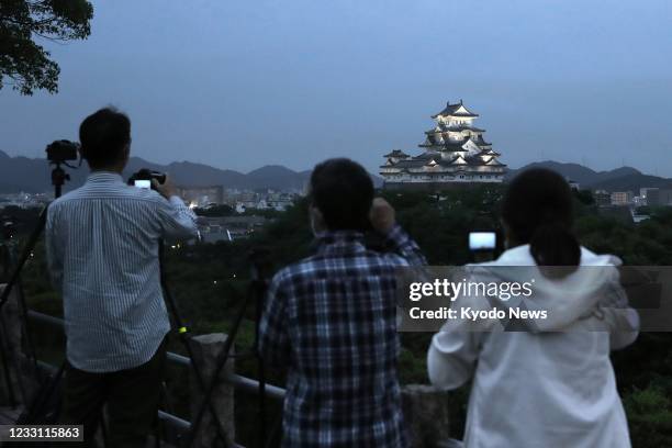 People in the Hyogo Prefecture city of Himeji, western Japan, wait to see a total lunar eclipse on May 26 with Himeji Castle seen in the background.