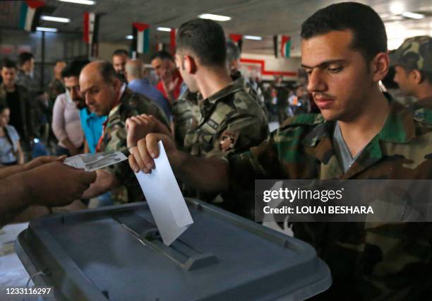 Syrian soldiers cast their ballots at a polling station in Damascus on May 26 as voting for Syria's presidential election started in government-held...