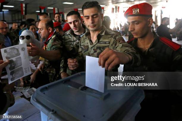 Syrian soldiers cast their ballots at a polling station in Damascus on May 26 as voting for Syria's presidential election started in government-held...