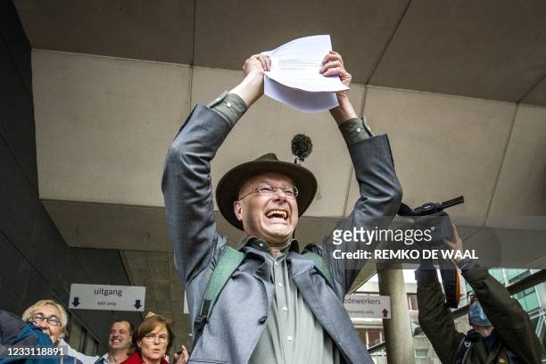 Director of Dutch environment organisation 'Milieudefensie' Donald Pols reacts as he walks outside a court in The Hague on May 26 after the district...