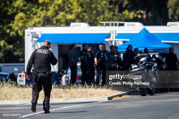 Police officer walks through a parking lot near the site of a mass shooting at a Valley Transportation Authority light-rail yard on May 26, 2021 in...