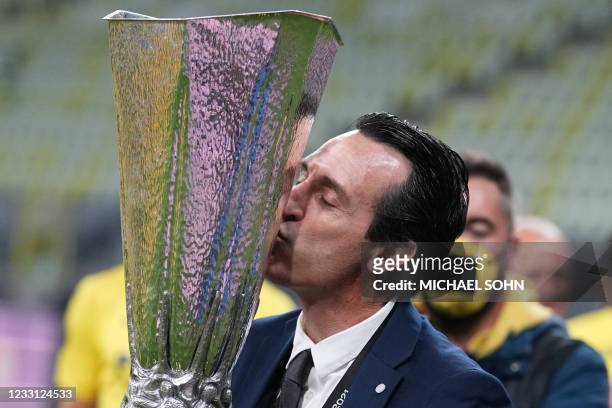 Villarreal's Spanish coach Unai Emery poses for pictures with the trophy after winning the UEFA Europa League final football match between Villarreal...