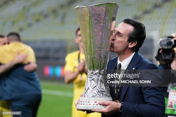 Villarreal's Spanish coach Unai Emery kisses the trophy as he celebrates winning the UEFA Europa League final football match between Villarreal CF...