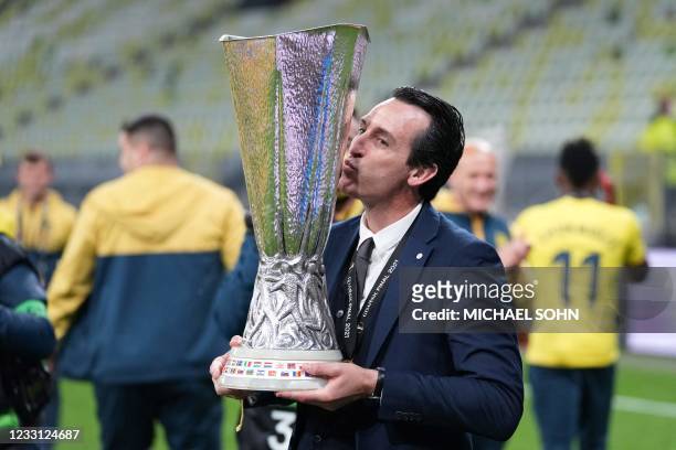 Villarreal's Spanish coach Unai Emery poses for pictures with the trophy after winning the UEFA Europa League final football match between Villarreal...