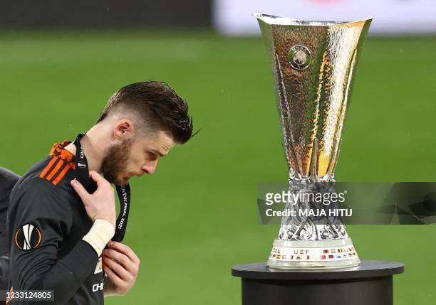 Manchester United's Spanish goalkeeper David de Gea walks past the trophy after their defeat in the UEFA Europa League final football match between...