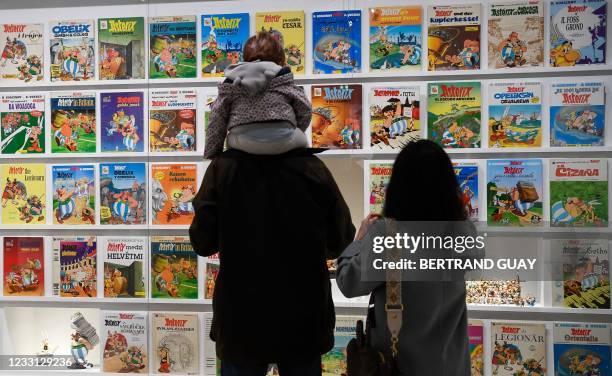 Visitors look at comics displayed during the exhibition 'Uderzo like a magic potion' at the Maillol Museum, in Paris, on May 26, 2021. - The...