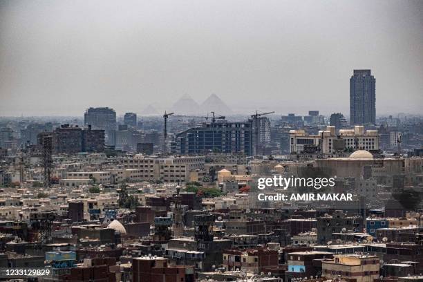 This picture taken on May 26, 2021 from the Cairo Citadel shows a view of the skyline of Egypt's capital Cairo and its twin city of Giza , showing in...