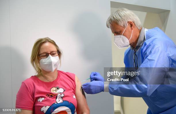 Doctor Christoph Borch gives a woman an injection against COVID-19 in the Babelsberg vaccination center following the presentation of the digital...