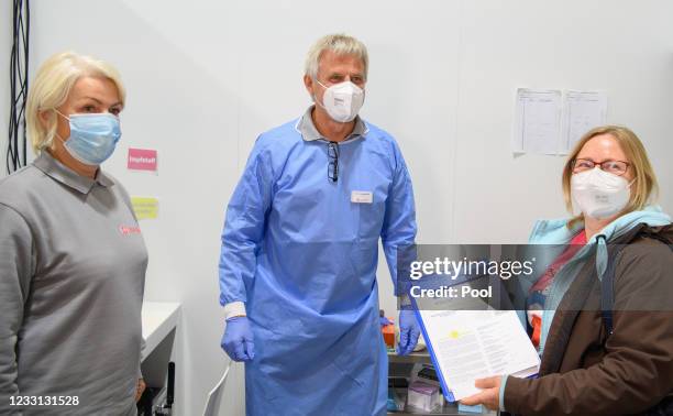 Doctor Christoph Borch shows a woman example of a digital vaccination pass in the Babelsberg vaccination center, after her vaccination against...