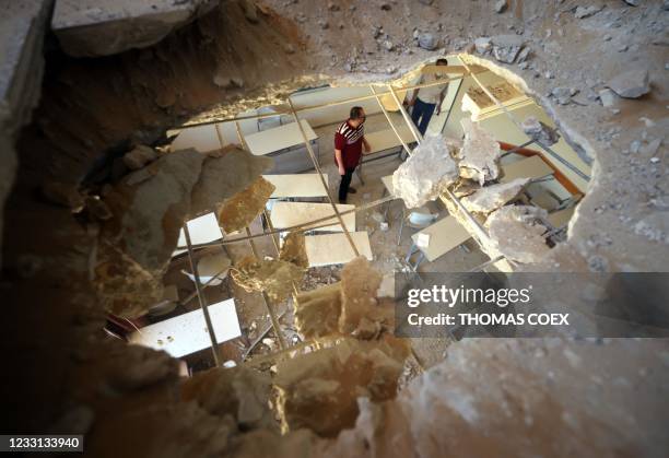 Palestinian men check items in a classroom at a school hit during shelling at the Zeitun neighbourhood in Gaza City, on May 27, 2021. - A ceasefire...