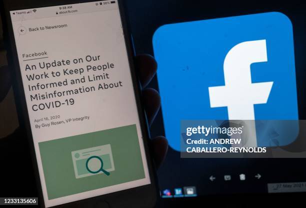 In this photo illustration, a smart phone screen displays a new policy on Covid-19 misinformation with a Facebook website in the background, on May...