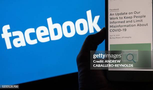 In this photo illustration, a smart phone screen displays a new policy on Covid-19 misinformation with a Facebook website in the background, on May...