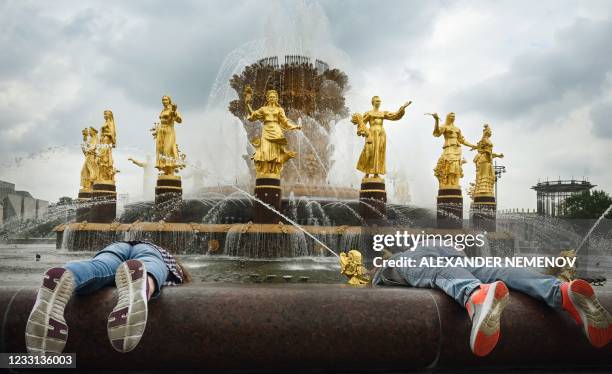 Children try to get coins out of the "Friendship of Nations" fountain, built in 1954, symbolising the friendship of sixteen Soviet republics forming...