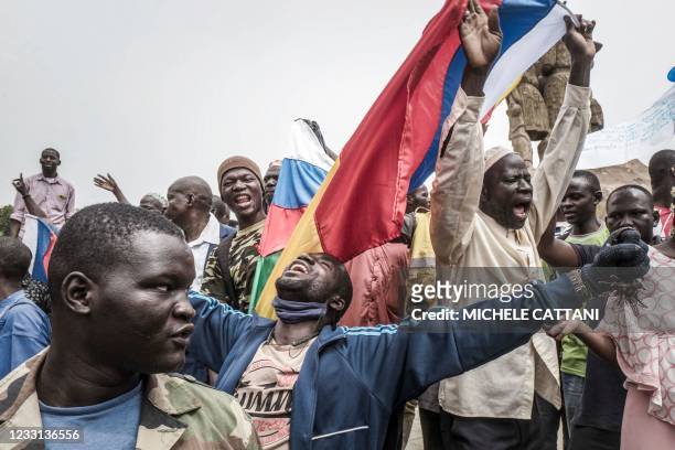 Russians and Malian flags are waved by protesters in Bamako, during a demonstration against French influence in the country on May 27, 2021. - The...