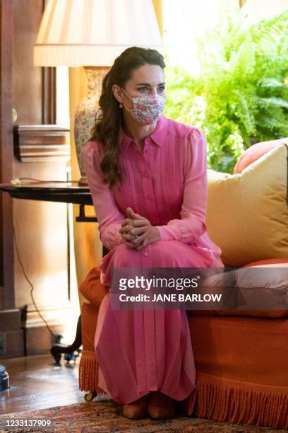 Britain's Catherine, Duchess of Cambridge gestures as she meets five year-old Mila Sneddon, a cancer patient who featured in an image from the Hold...