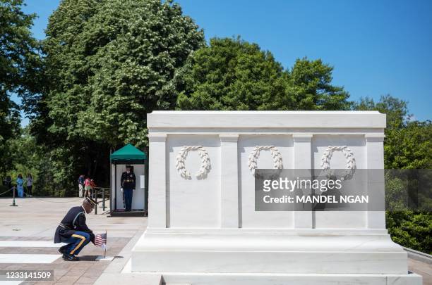 Soldier from the 3rd US Infantry Regiment, the "Old Guard", places a US flag at the Tomb of the Unknown Soldier in Arlington National Cemetery in...