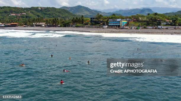 Aerial view of surfers swimming in the ocean on May 27, 2021 in San Salvador, El Salvador. From May 29 to June 6, La Bocana beach will host the ISA...