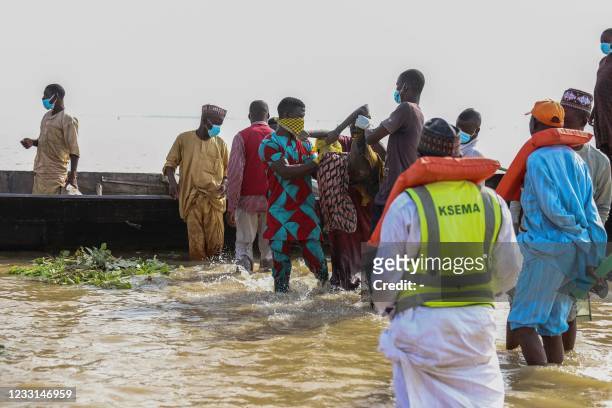 Graphic content / Men carry the body of a man out of the water in Ngaski, Nigeria, on May 27, 2021 after an overloaded boat sank in the Niger River...