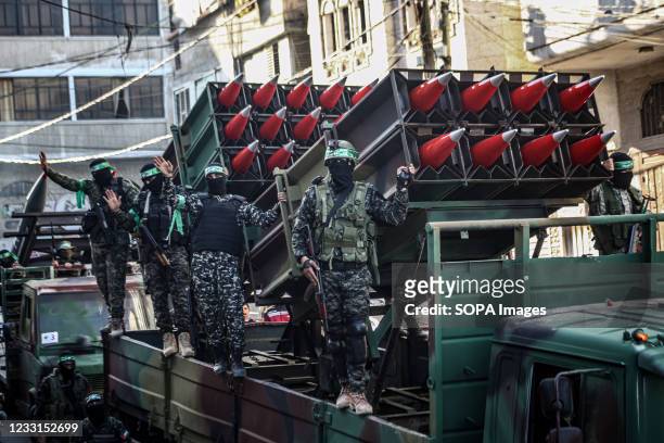 Members of the Izz al-Din al-Qassam Brigades, the military wing of Hamas display rockets during a military parade on the Streets in Khan Yunis,...