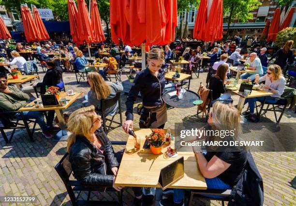Customers are served on a cafe terrace in the centre of The Hague on May 28, 2021. - Netherlands OUT / Netherlands OUT