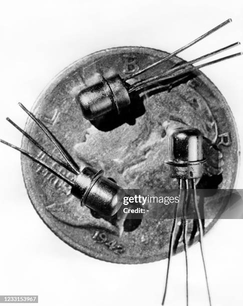 Picture dated 1956 of miniature M-1 transistors seen on the face of a ten-cent piece, the smallest yet developed. The world's first transistor was...