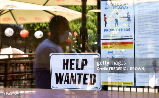 Help Wanted' sign is posted beside Coronavirus safety guidelines in front of a restaurant in Los Angeles, California on May 28, 2021. - Following...