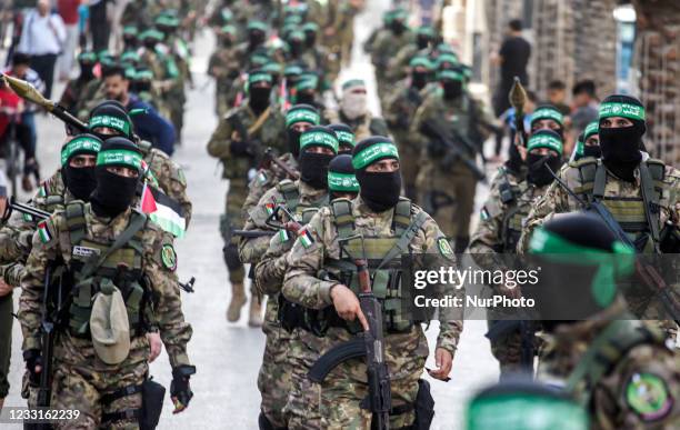 Members militants from the Ezz-Aldine Al-Qassam Brigades, a military wing of Hamas, marching with their guns in the streets of Nuseirat refugee camp,...