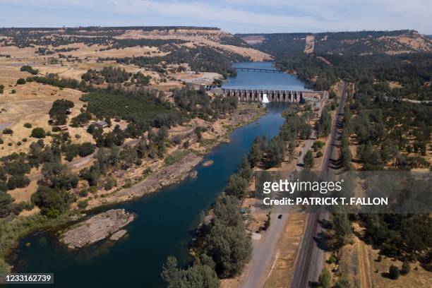 In this aerial image, water flows down the Feather River below the Lake Oroville during the California drought emergency on May 27, 2021 in Oroville,...