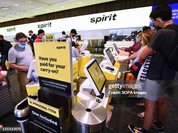 Travelers check in for a Spirit Airlines flight at Orlando International Airport on the Friday before Memorial Day. As more and more people have...