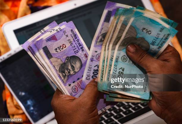 An indian man counts indian rupee currency in Tehatta, West Bengal, India on 29 May 2021. Indian currency rupee has staged a strong comeback,...