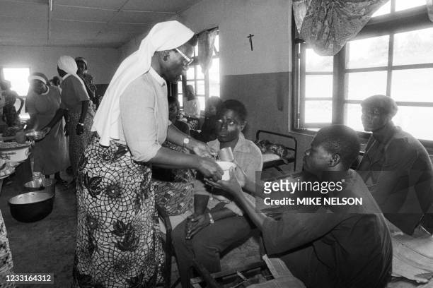 Sisters at the Catholic Mission of Wum distibutes food to people who fled the gas disaster area around lake Nyos on August 29, 1986 after the...