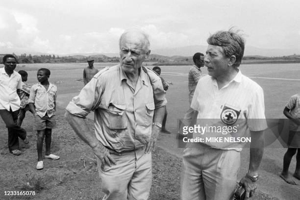 French volcanologist Haroun Tazieff speaks with a member of the Red Cross in Bamenda on August 29, 1986 after investigating the cause of the gas...