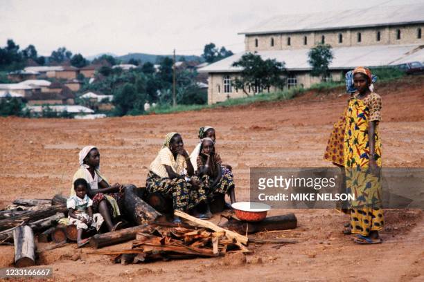 People who fled the gas disaster area around lake Nyos sit on a pieces of wood at Wum catholic mission on August 29, 1986 after the explosion of the...