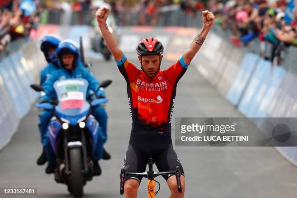 Team Bahrain rider Italy's Damiano Caruso celebrates as he crosses the finish line to win the 20th stage of the Giro d'Italia 2021 cycling race,...