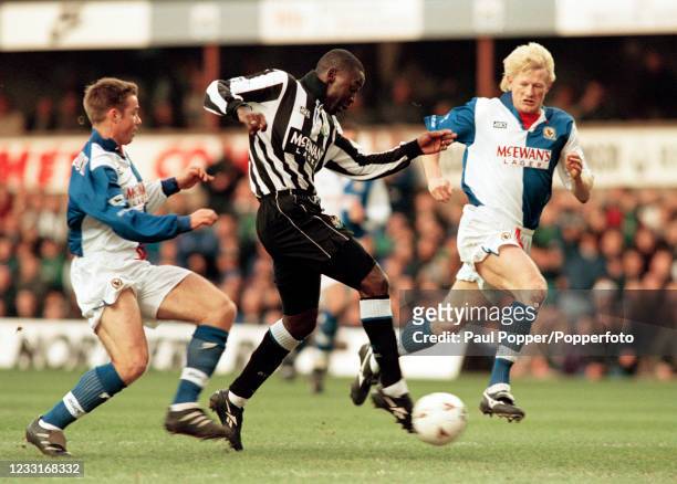 Andrew Cole of Newcastle United shoots towards goal watched by Graeme Le Saux and Colin Hendry of Blackburn Rovers during an FA Carling Premiership...