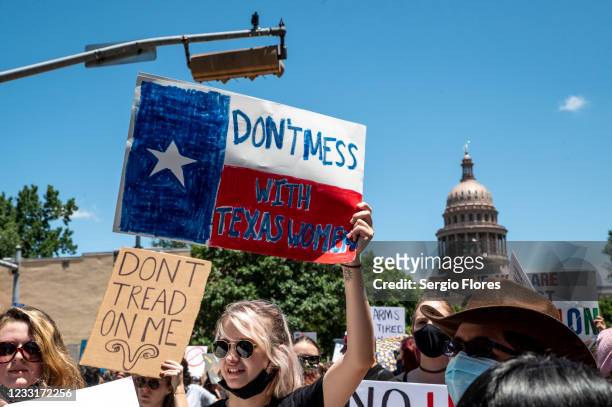 Protesters hold up signs as they march down Congress Ave at a protest outside the Texas state capitol on May 29, 2021 in Austin, Texas. Thousands of...