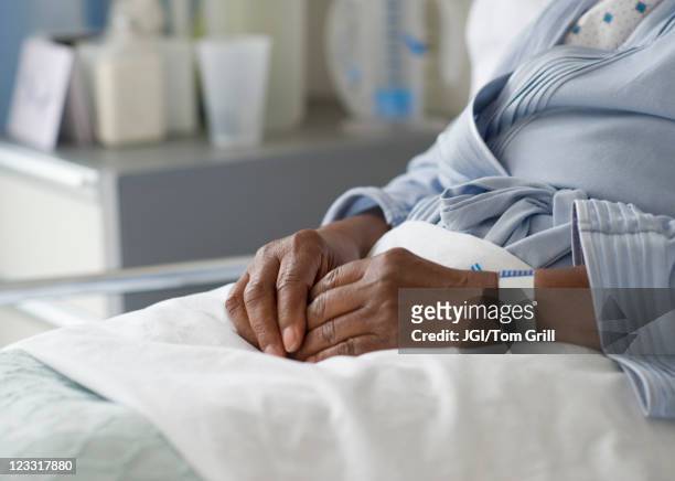 black woman recovering in hospital bed - hospital bed stockfoto's en -beelden