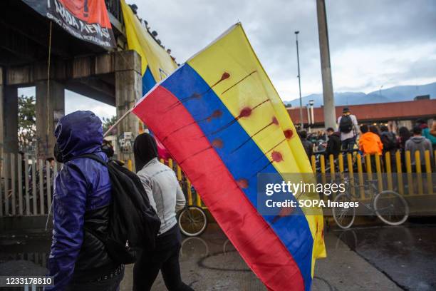 Colombian flag with blood on it, is held by a protester during the national strike, in Plaza de Los Heroes . On the 28th of May, a month after the...