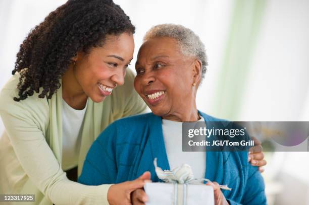 daughter giving mother birthday gift - african gift stock pictures, royalty-free photos & images