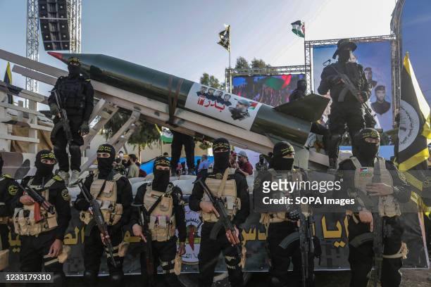 Fighters from the Saraya al-Quds Brigades, the armed wing of the Palestinian Islamic Jihad movement pose in front of a rocket during the parade on...