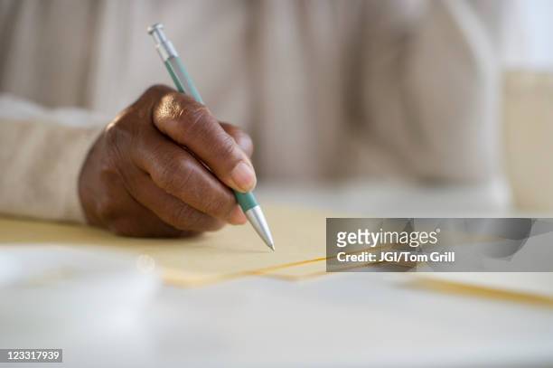 black woman writing letter - holding pen in hand stock pictures, royalty-free photos & images