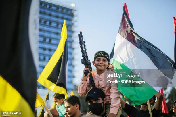 Supporters of the Saraya al-Quds Brigades, the armed wing of the Palestinian Islamic Jihad movement, attend the parade on the streets of Gaza City....