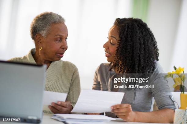 daughter helping mother pay bills online - bill assistance stock pictures, royalty-free photos & images