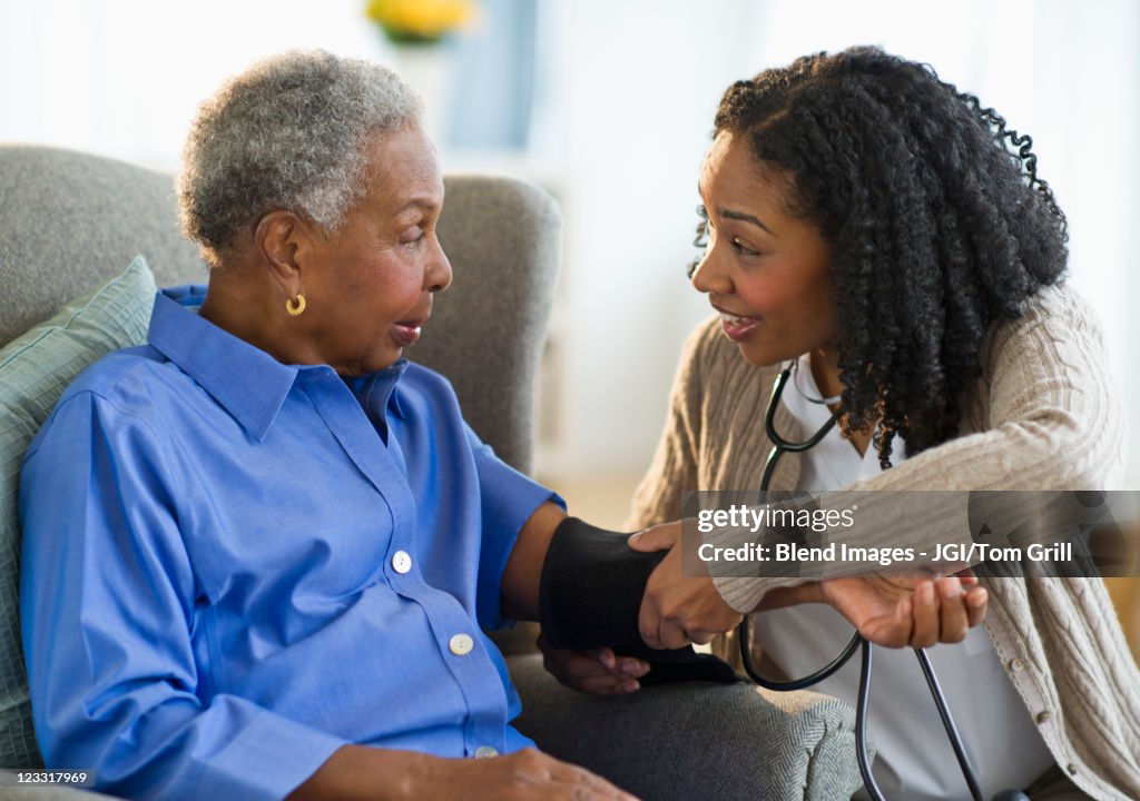 Nurse taking woman's blood pressure
